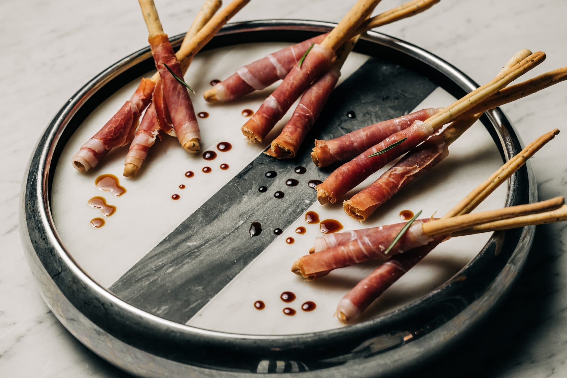 Prosciutto-wrapped grissini on a marble tray drizzled with balsamic vinegar at the Meta APEX Center, a premier event venue in Las Vegas